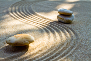 slyngende mønstre i sand med tre sten 